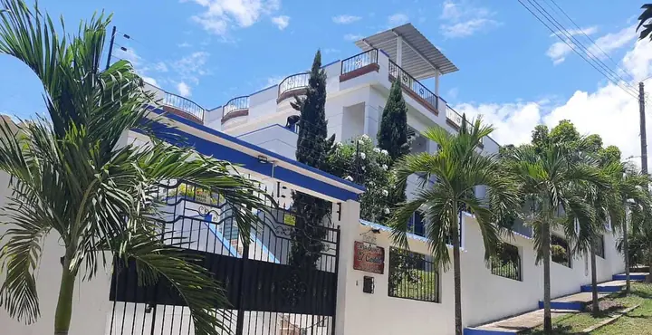 Fachada blanca con remates azules de Casa Quinta El Castillo en el barrio Los Cristales