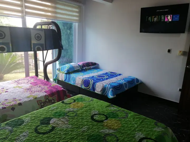Habitación con camas sencillas, camarote y televisor