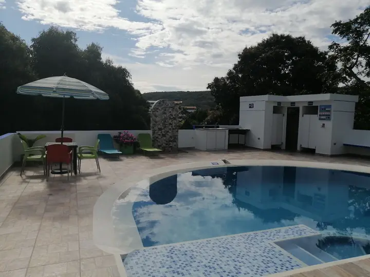 Piscina privada de Casa Quinta El Castillo en Melgar, con parasol, mesa y asoleadoras